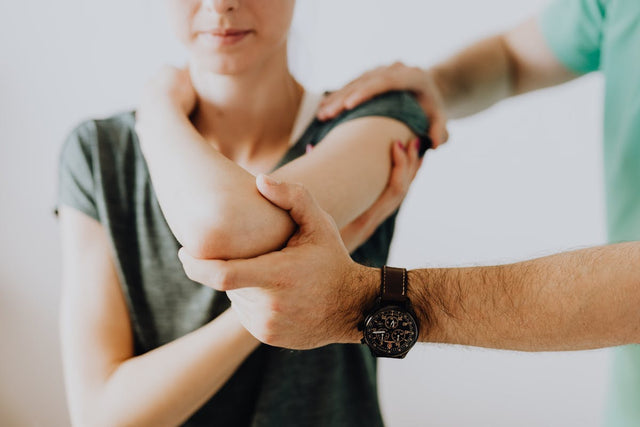 Chiropractor examining arm joint