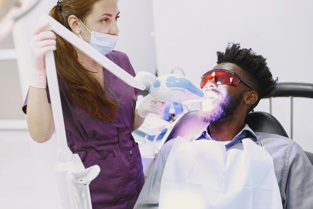 Dentist performing teeth whitening